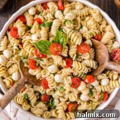 Caprese Pasta Salad in a bowl, garnished with fresh basil leaves