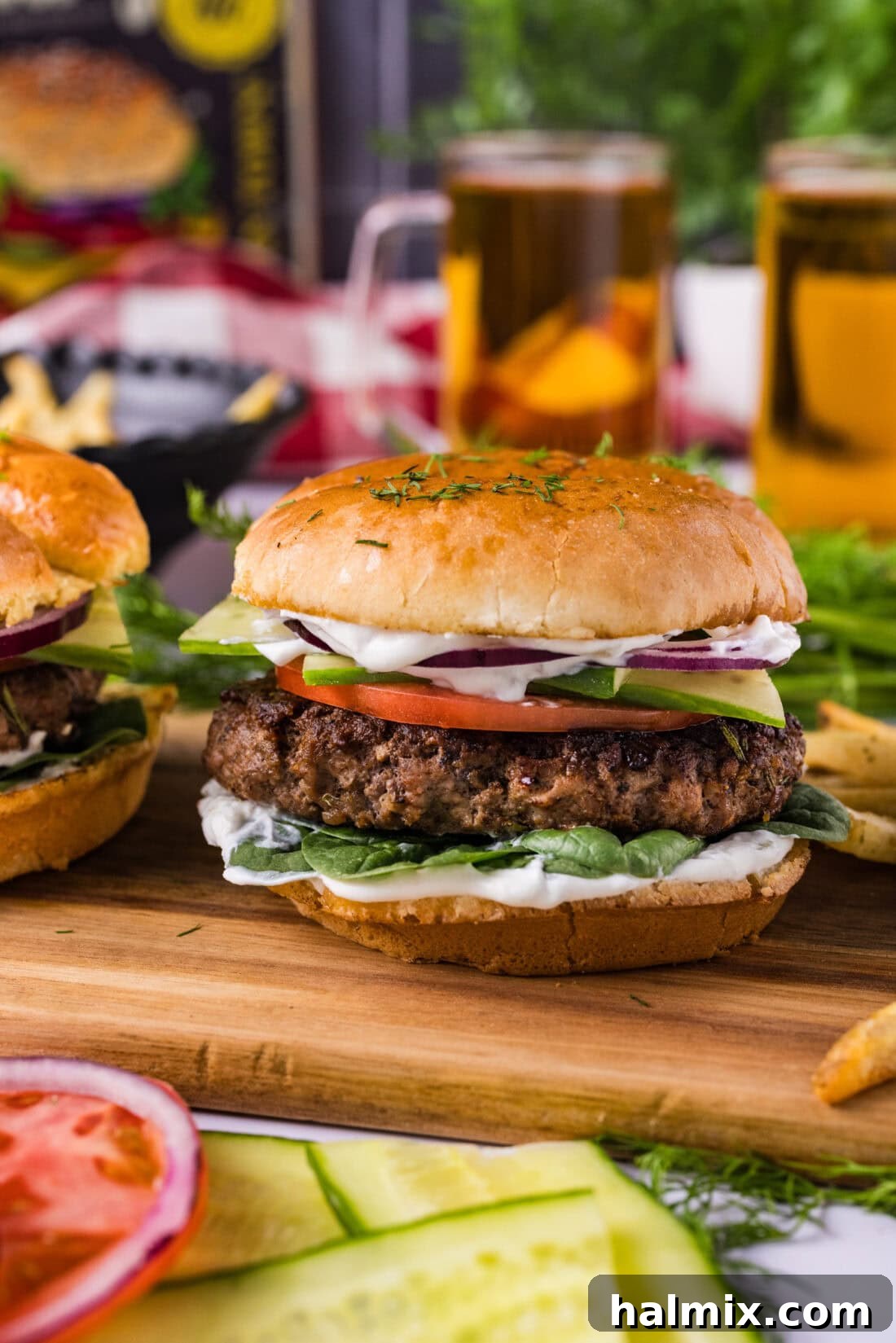 A perfectly assembled lamb burger on a rustic wooden board