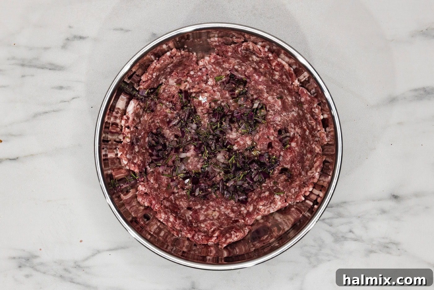 Ground lamb mixed with seasonings in a bowl, ready for patty formation