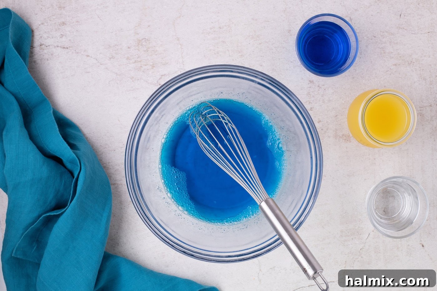Whisk in a bowl with water and blue jello mixture