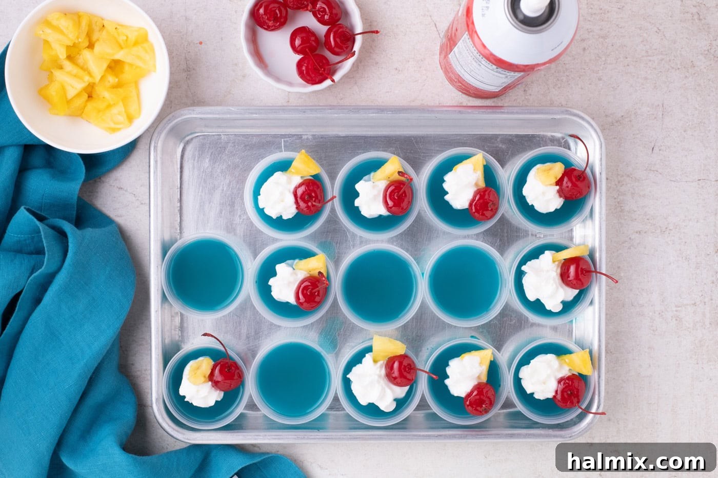 blue hawaiian jello shots with whipped cream, cherries, and pineapple