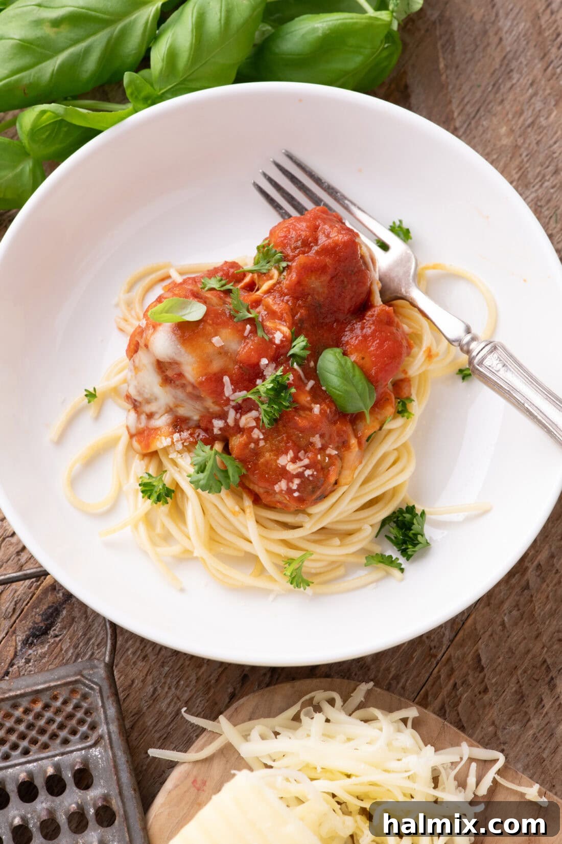 Chicken Parmesan Meatballs plated over spaghetti 