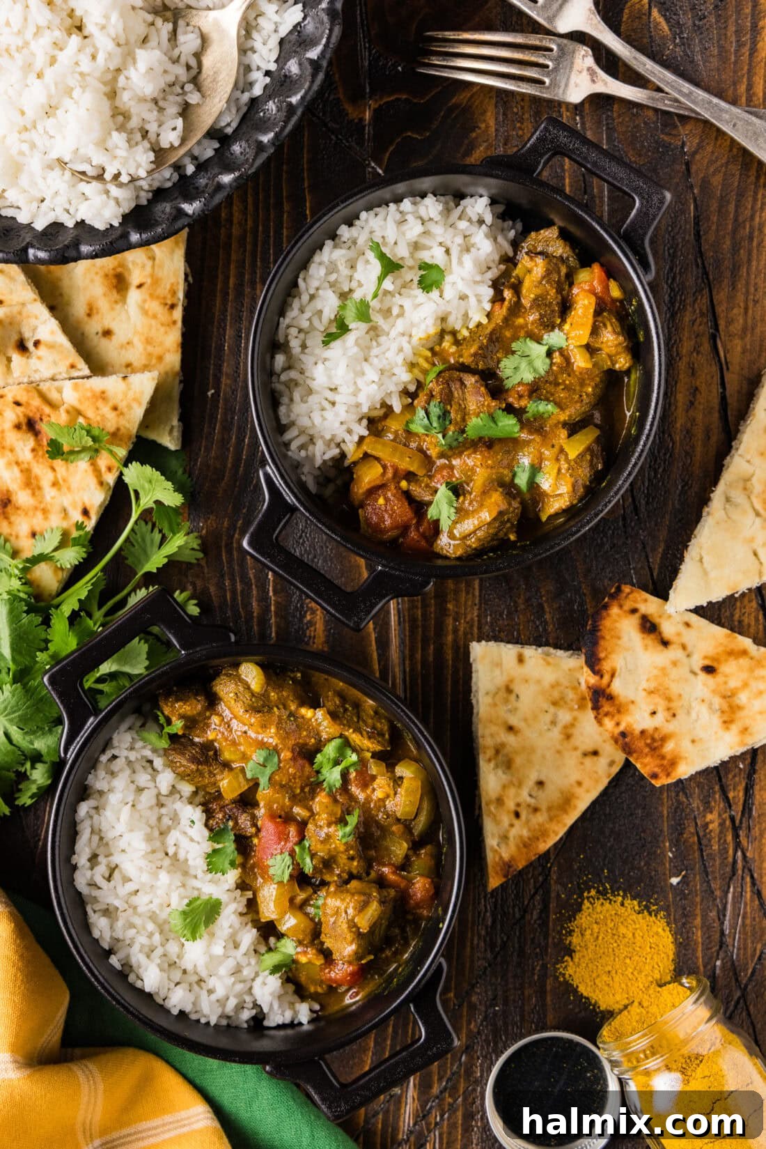 Two bowls of Beef Curry with rice, garnished with fresh herbs