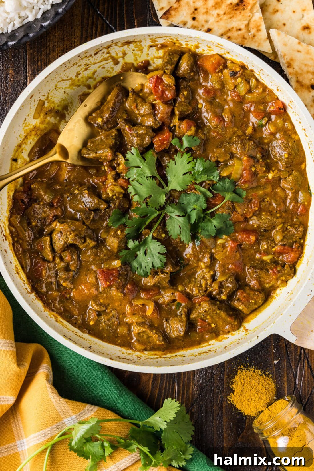 Skillet of Beef Curry with a serving spoon resting inside