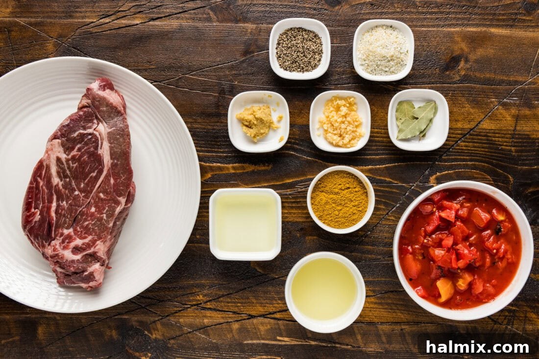 Collection of fresh ingredients for Beef Curry, including beef chunks, spices, tomatoes, and wine