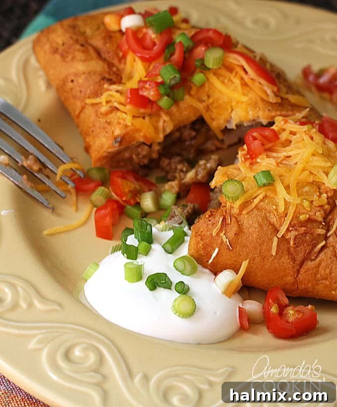 These taco empanadas are easy to make and are a great weeknight meal. Taco hand pies are perfect for leftover taco meat! Easy to eat on the go as well! cut in half taco empanada