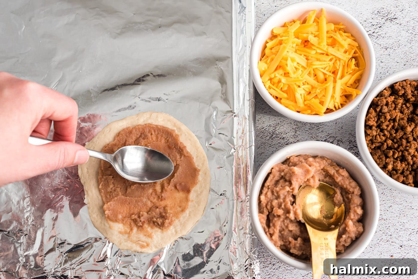 Fiesta Taco Pockets 6 spreading refried beans on biscuit dough
