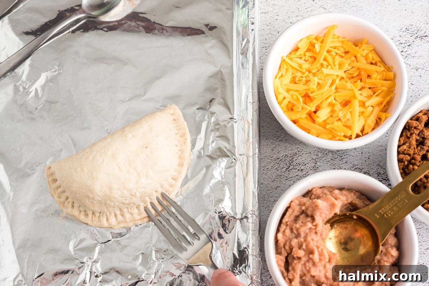 Fiesta Taco Pockets 10 sealing empanadas with a fork