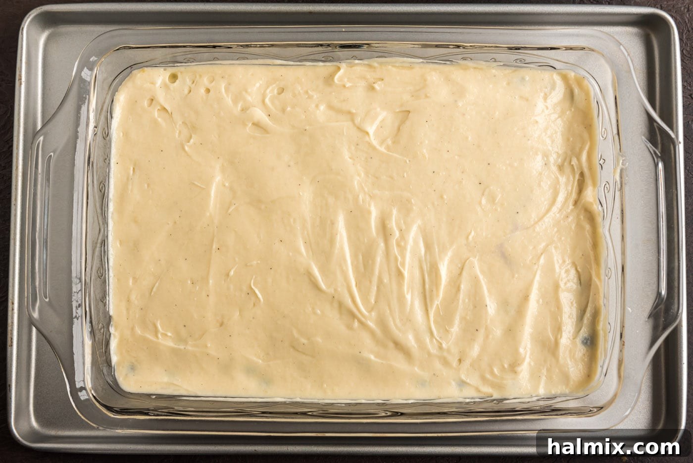 Blueberry Crown Cake 12 The baking dish is now filled with the full cake batter, spread smoothly over the blueberry and brown sugar base, ready to be transferred to the oven for baking.