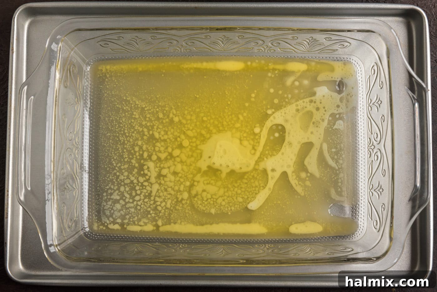 Blueberry Crown Cake 7 The butter has now fully melted, forming a glistening, golden pool that evenly coats the bottom of the glass baking dish, providing a rich base for the blueberry topping.