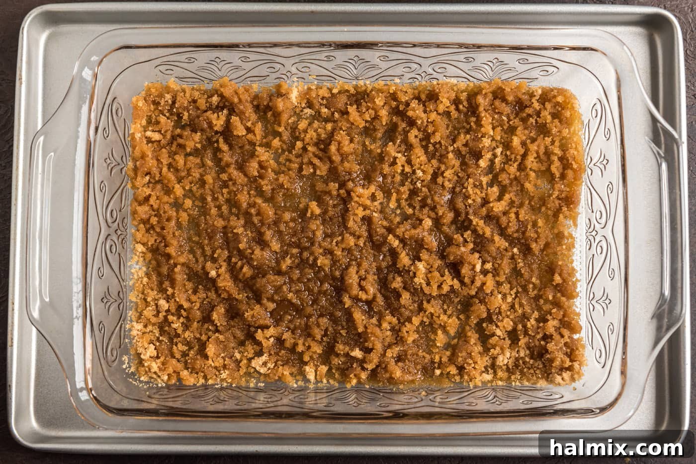 Blueberry Crown Cake 9 A close-up view of the baking dish, where a rich mixture of melted butter and brown sugar has been evenly combined, creating a sticky, sweet base for the fruit.
