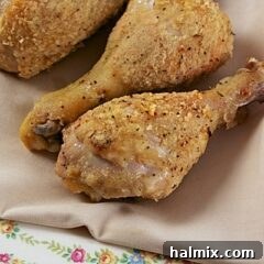 A close up photo of oven fried chicken drumsticks.