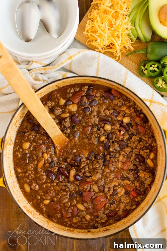 Overhead view of a Dutch oven filled with simmering 3 bean chili, showing its rich color and hearty texture.