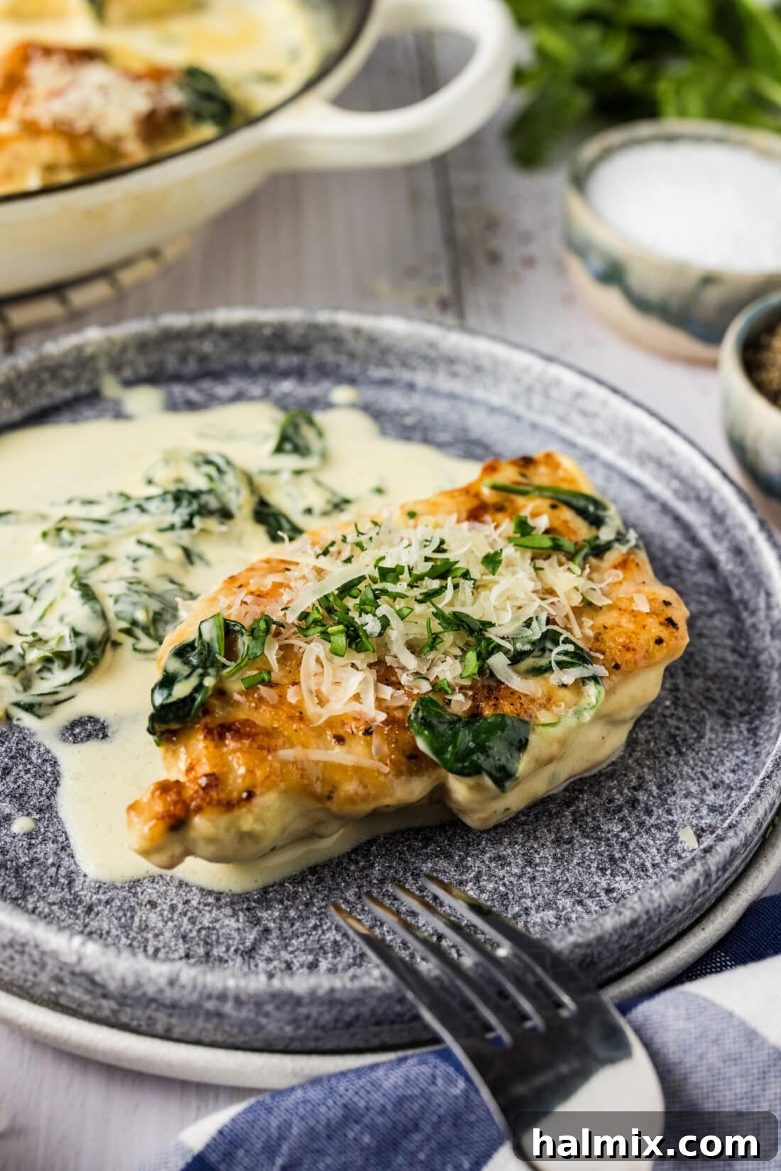 Chicken Florentine served on a white plate with a fork, showing the creamy sauce and spinach