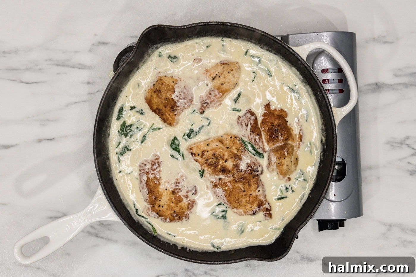 finished Chicken Florentine dish in a skillet with creamy sauce covering the chicken