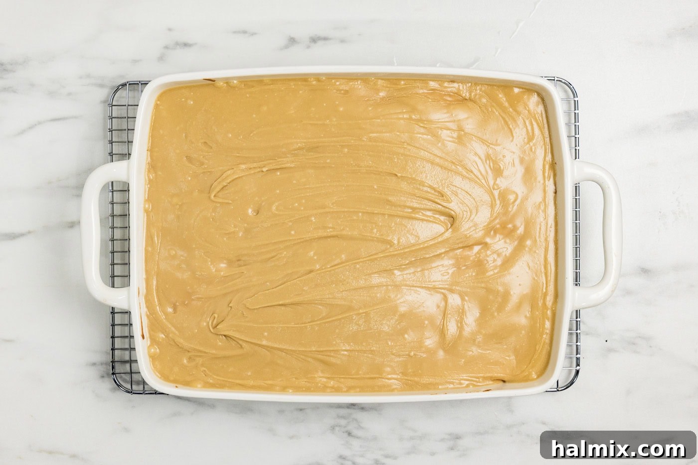 caramel icing spread over peach cake in a dish