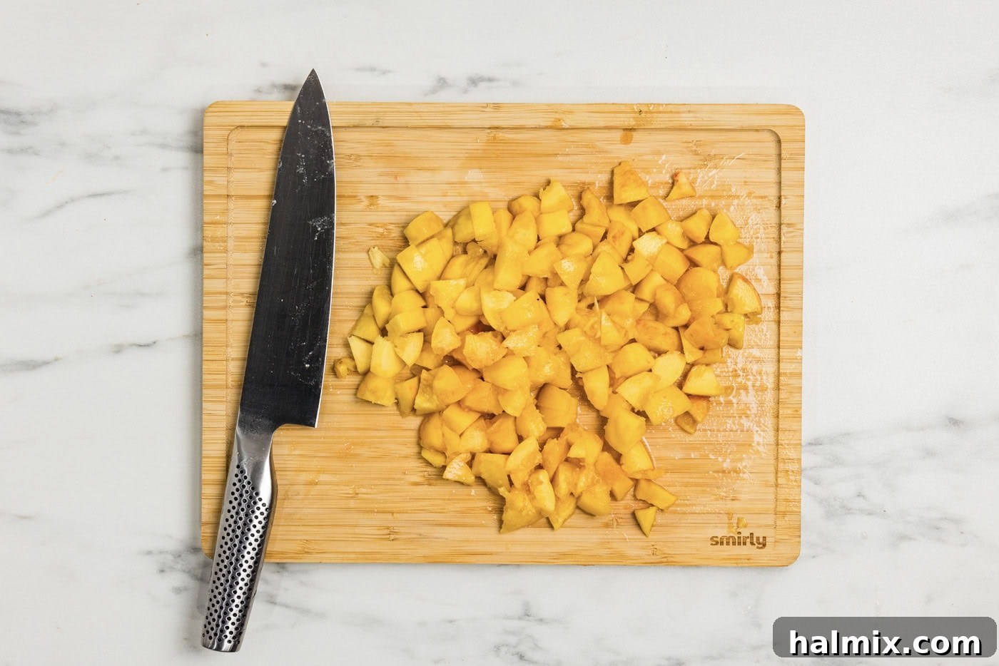 chopped peaches on a cutting board with a knife