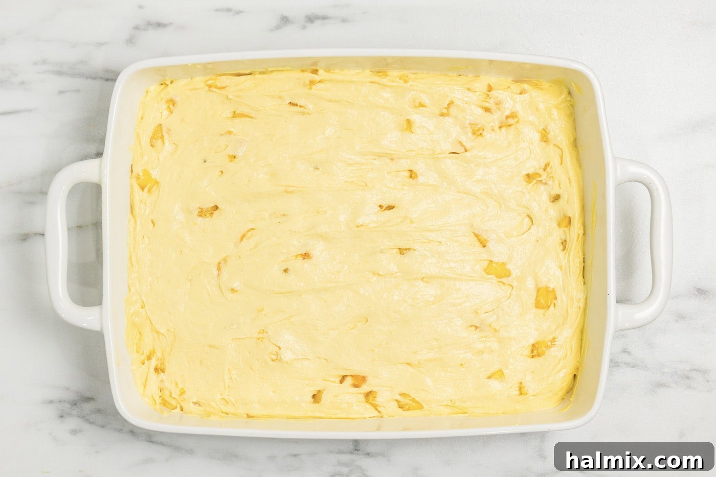 peach cake batter in a baking dish