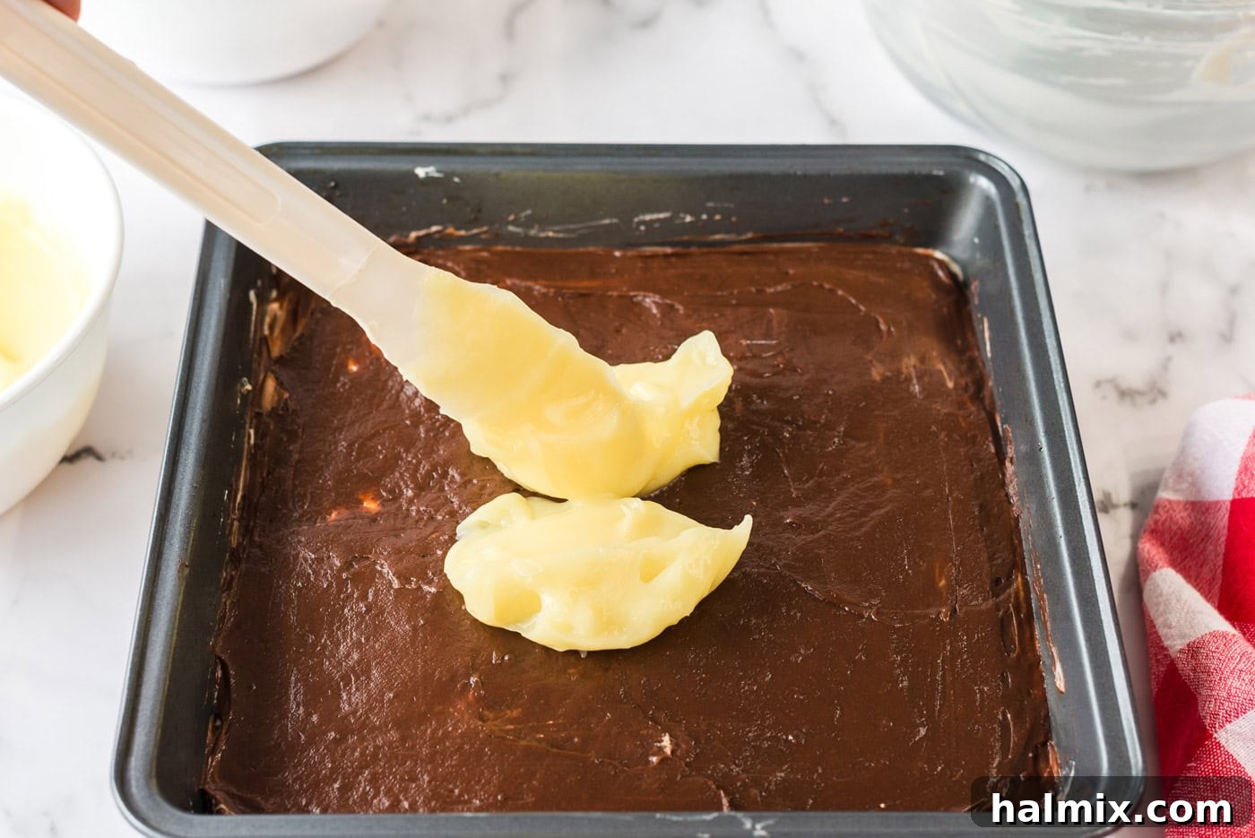 Pure Bliss Pan Dessert 11 The light vanilla pudding being dolloped and gently spread over the rich chocolate pudding layer, creating another distinct stripe.
