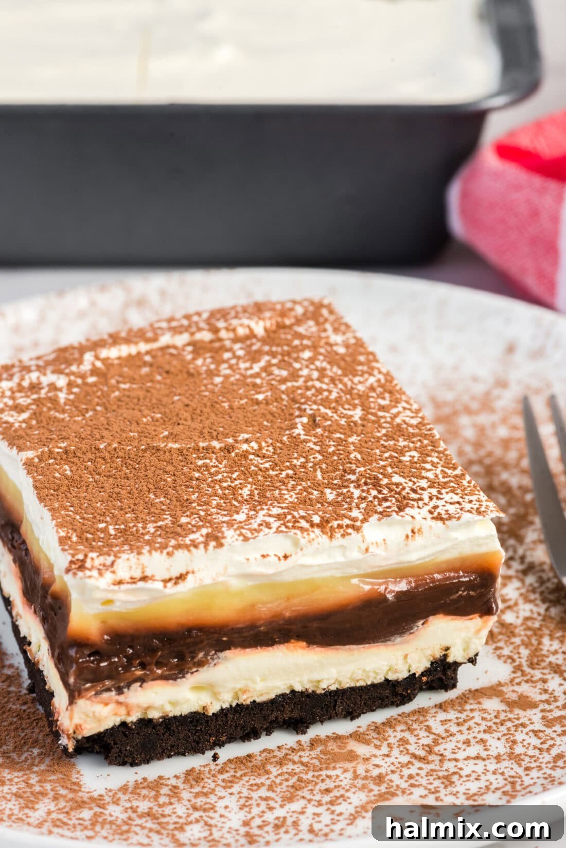 Pure Bliss Pan Dessert 14 A delectable slice of Sex in a Pan on a simple white plate, perfectly chilled and ready to be enjoyed.