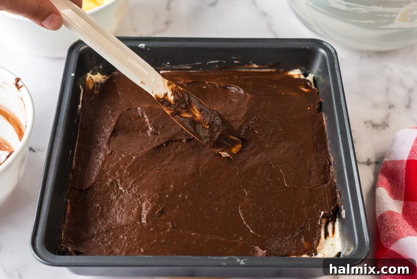 Pure Bliss Pan Dessert 10 A luscious layer of chocolate pudding being carefully spread over the white cream cheese filling in the dessert pan.