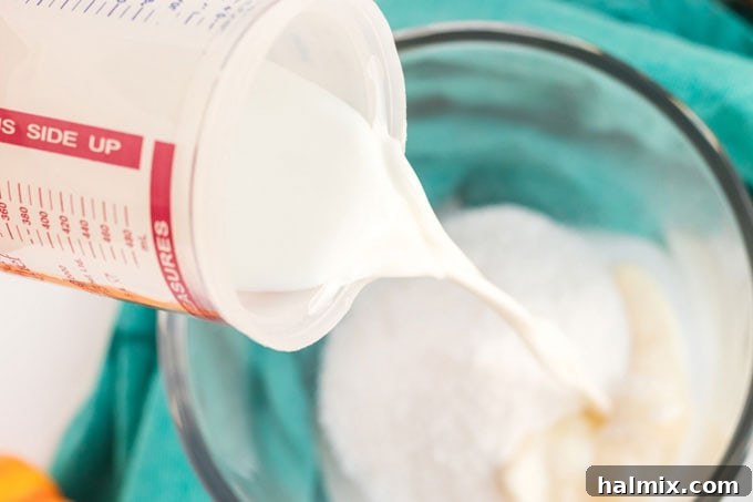 someone adding a package of pudding mix to a bowl with milk and spices