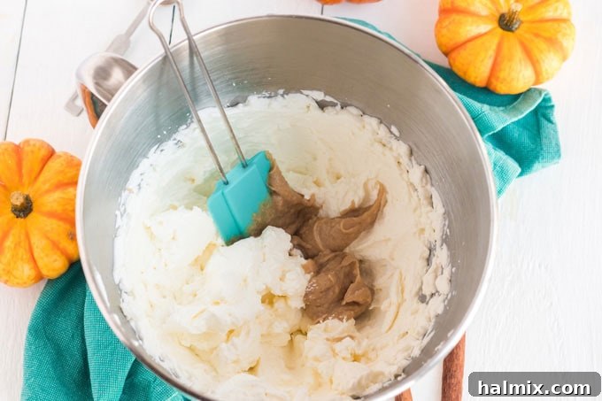 a rubber spatula gently folding pudding mixture into whipped cream in a bowl