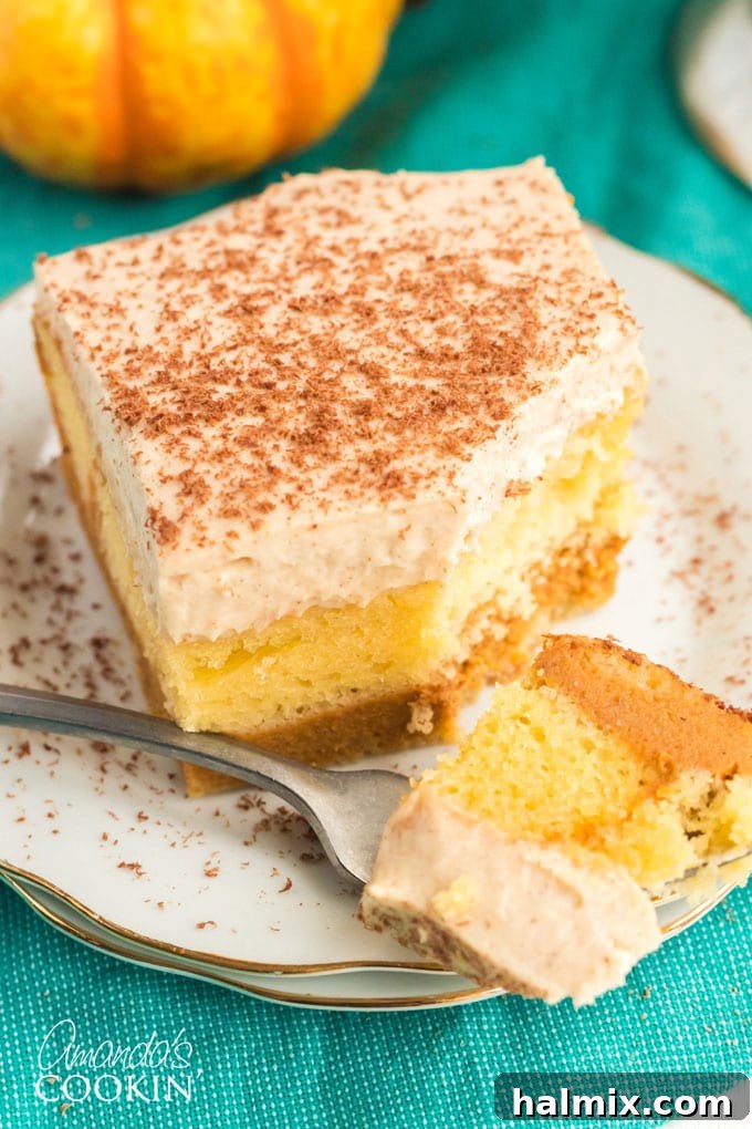 close-up of a forkful of magic pumpkin cake, showing the three distinct layers of cake, pumpkin, and topping