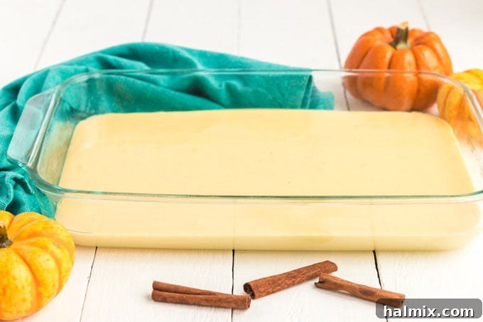 yellow cake batter poured into a clear glass 9x13 baking pan