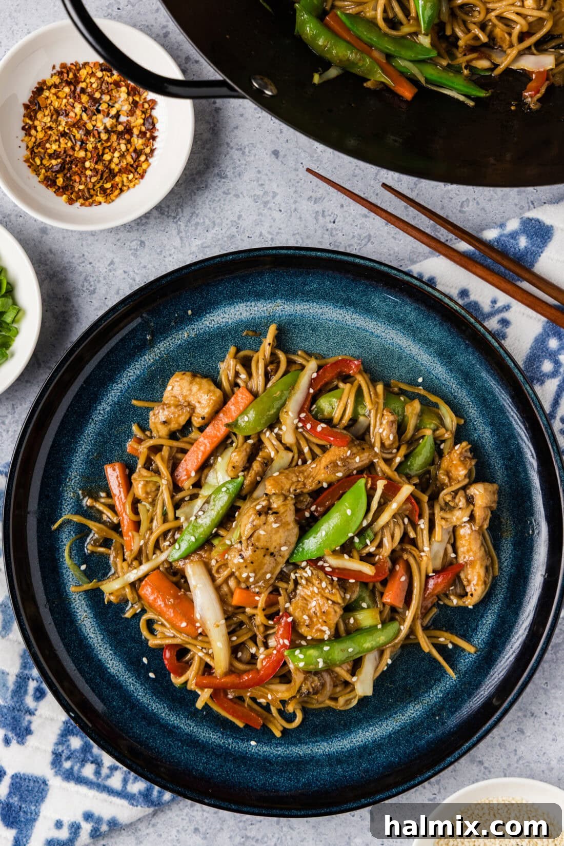 Flavorful Chicken Lo Mein Stir Fry 2 A vibrant plate of homemade Chicken Lo Mein with chopsticks and a wok in the background, showcasing fresh vegetables and tender chicken.