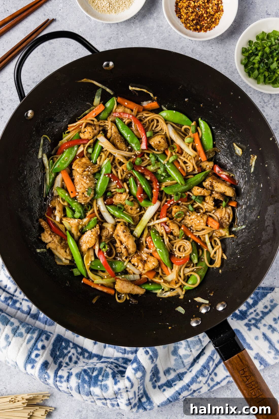 Flavorful Chicken Lo Mein Stir Fry 3 Close-up view of Chicken Lo Mein being stir-fried in a hot wok, showing the noodles, chicken, and vegetables coated in sauce.