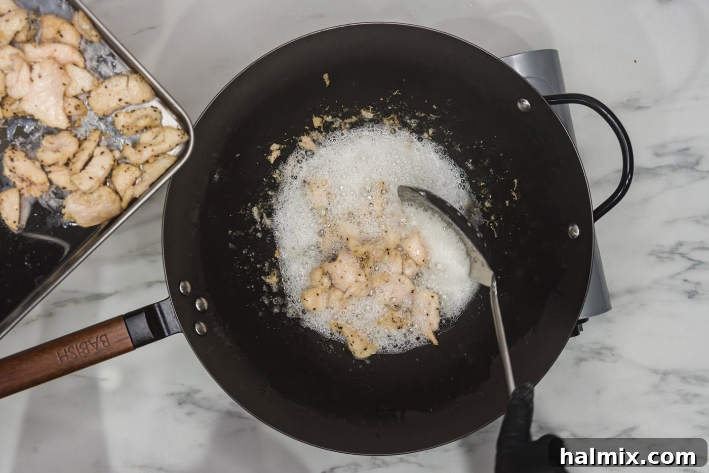 Flavorful Chicken Lo Mein Stir Fry 6 Cooked chicken pieces being removed from a wok with a slotted spoon after stir-frying.