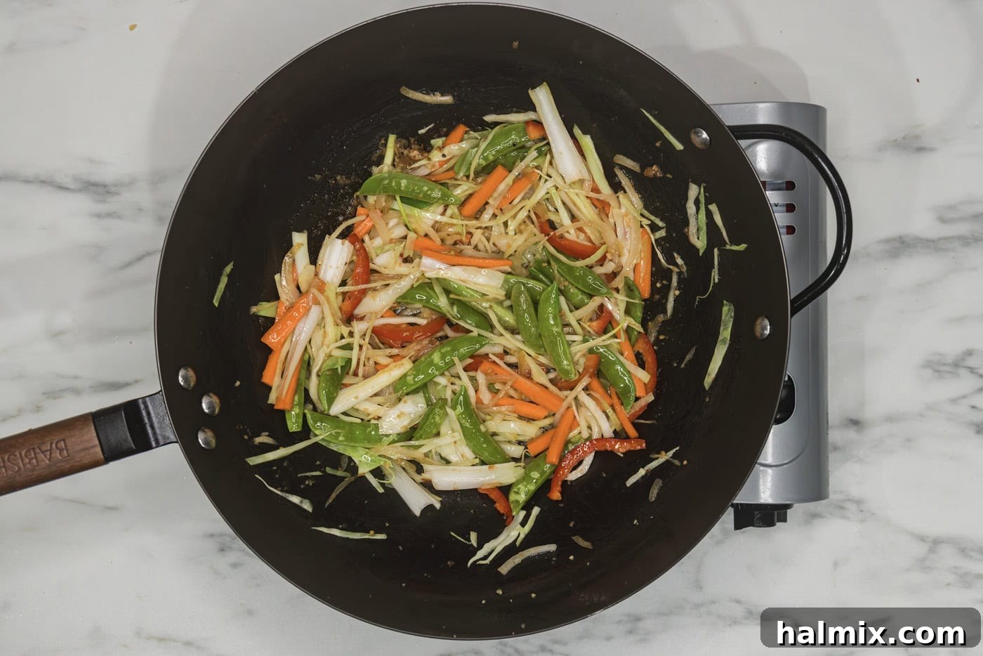 Flavorful Chicken Lo Mein Stir Fry 7 Assorted chopped vegetables, including bell peppers, onions, and carrots, actively stir-frying in a wok.