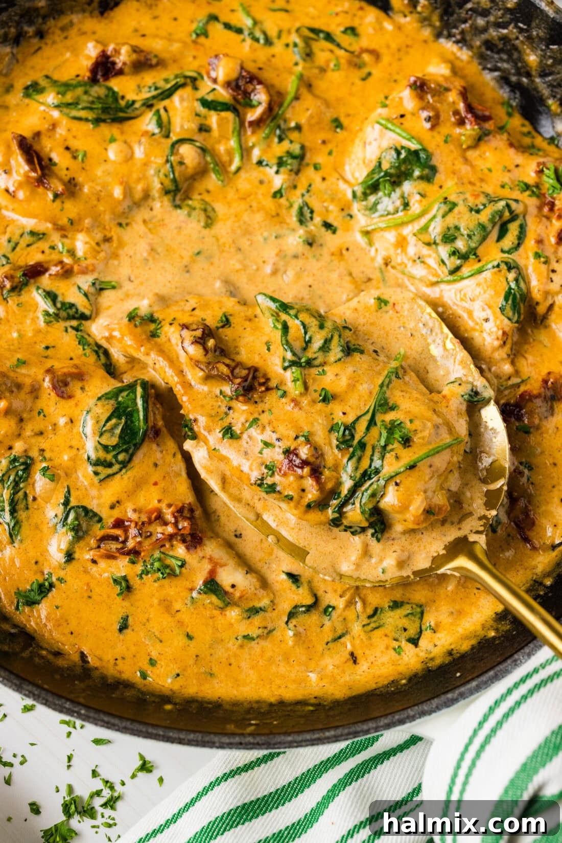 Creamy Sun-Dried Tomato Tuscan Chicken 3 Close up photo of a spatula in a skillet of Tuscan Chicken