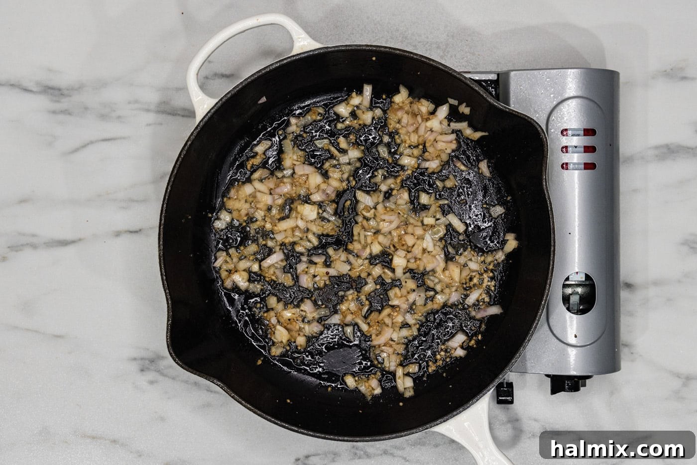 Creamy Sun-Dried Tomato Tuscan Chicken 6 garlic and shallots cooking in a skillet with butter