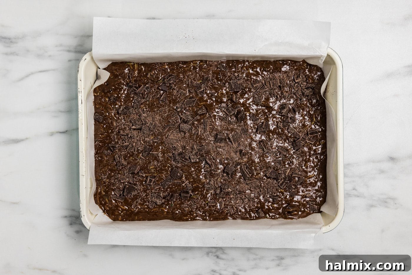 Hidden Veggie Fudge Brownies 11 zucchini brownie batter in a pan with chopped chocolate sprinkled on top