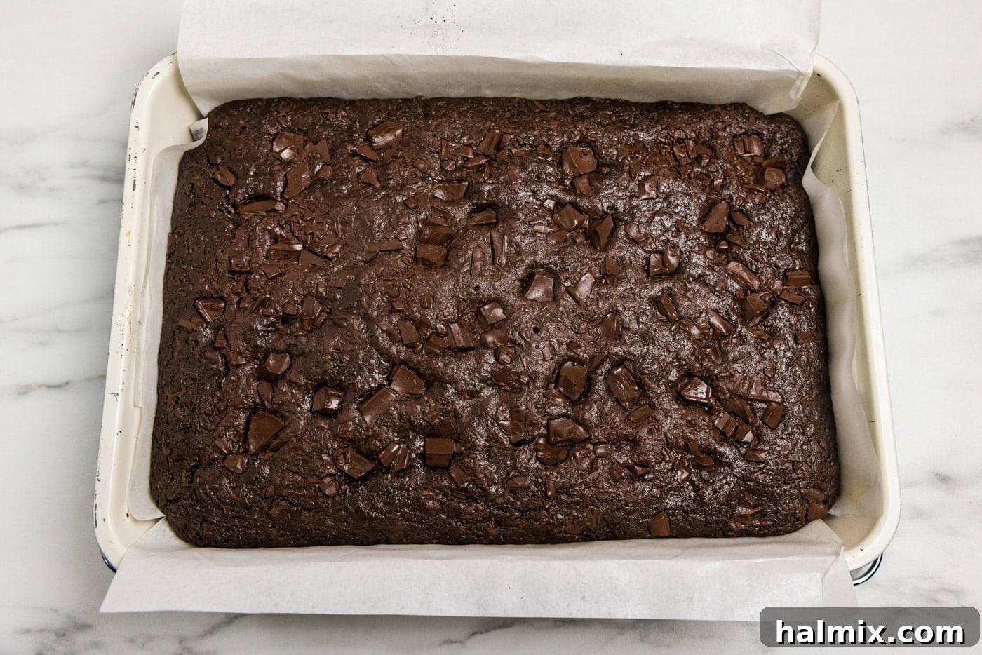 Hidden Veggie Fudge Brownies 12 pan of baked zucchini brownies with parchment paper over the side