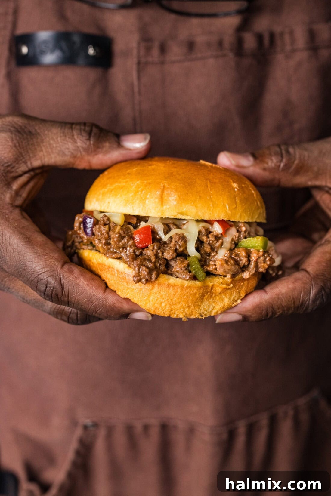 Hands holding a Philly Cheesesteak Sloppy Joe