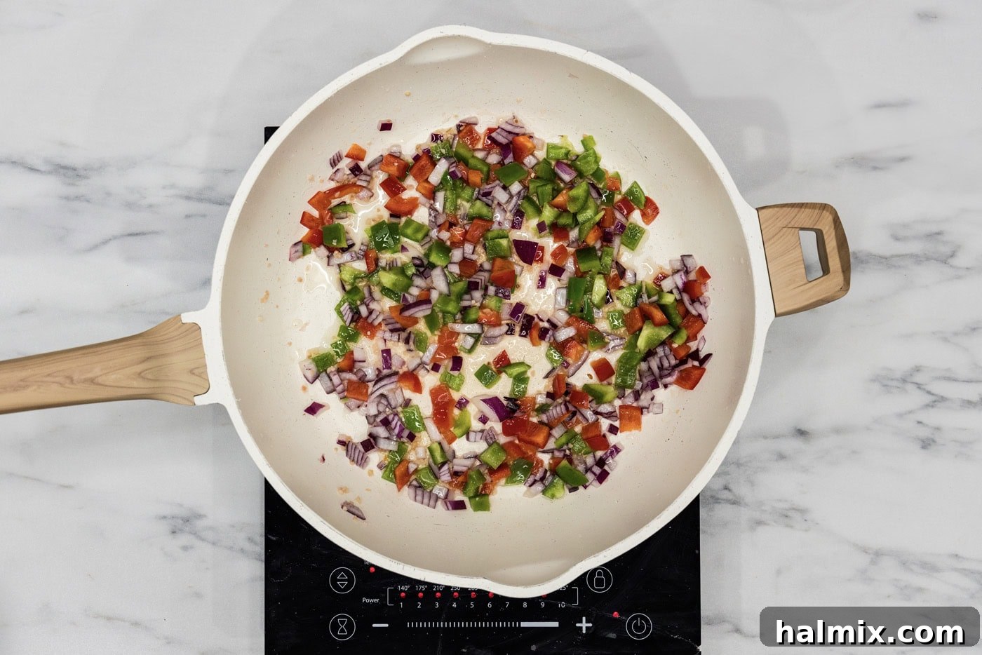 bell peppers, onion, and garlic sauteeing in a skillet