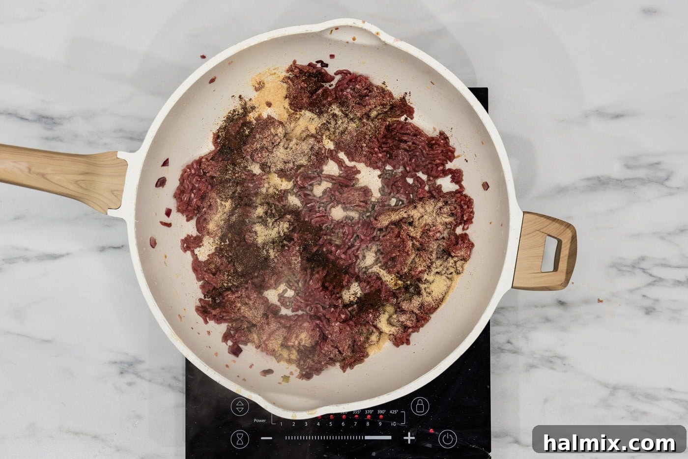 seasonings added on top of ground sirloin in a skillet