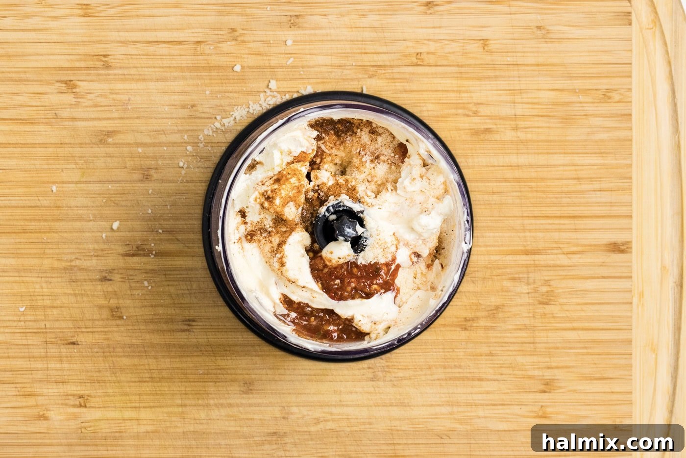 Overhead photo of all the sauce ingredients, including cream cheese, mayonnaise, and seasonings, in a mini food chopper, before blending.