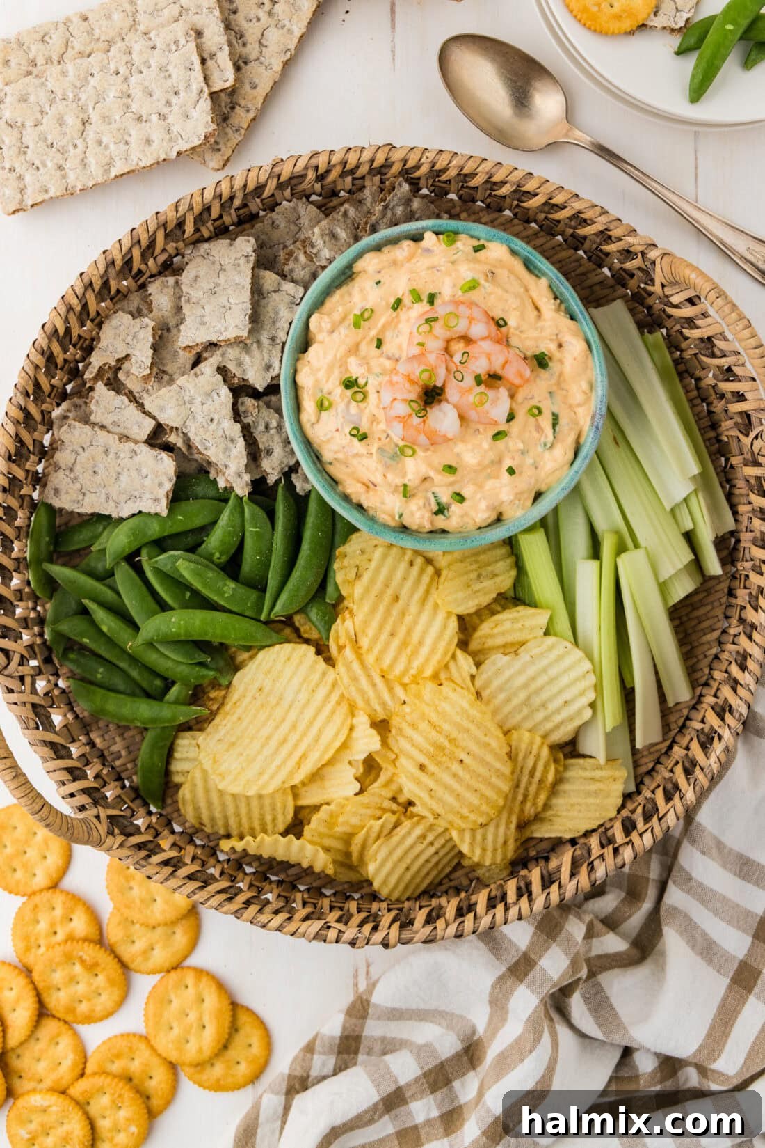 A beautiful bowl of Shrimp Dip artfully arranged on a platter with an assortment of chips and fresh vegetables.