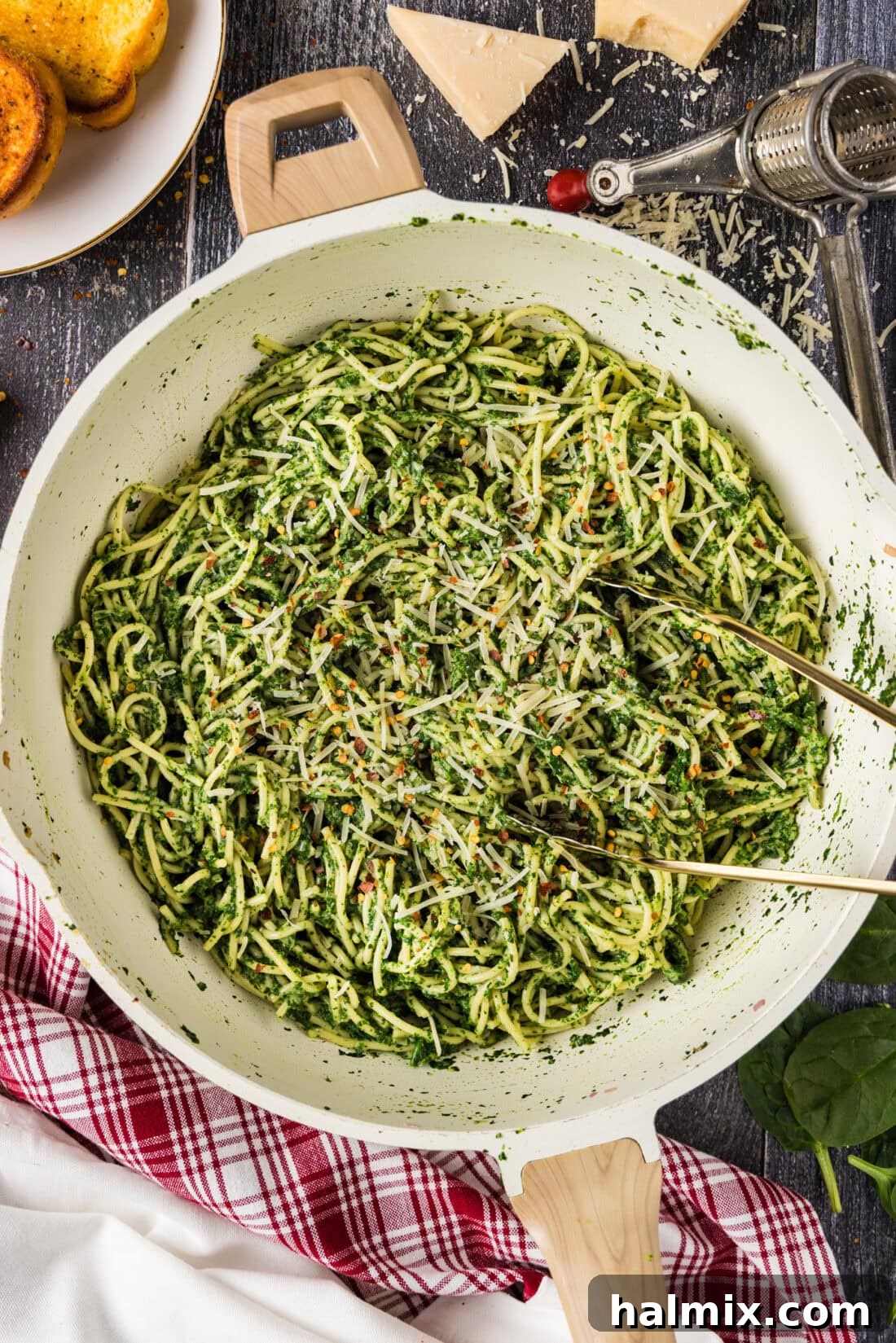 Skillet of Spinach Spaghetti with tongs in it, showcasing its creamy texture