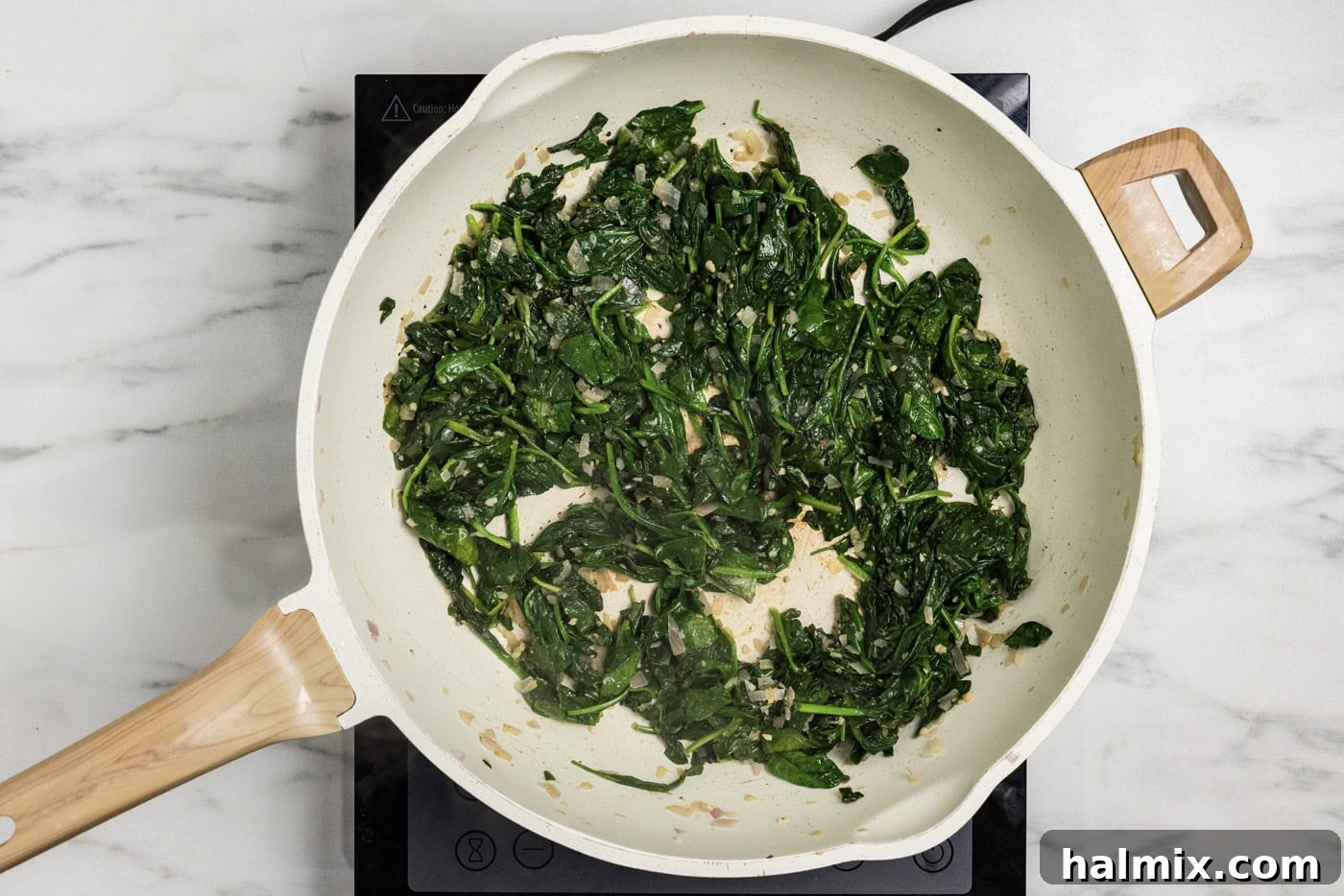 sauteed spinach mixture in a skillet, fully wilted and seasoned