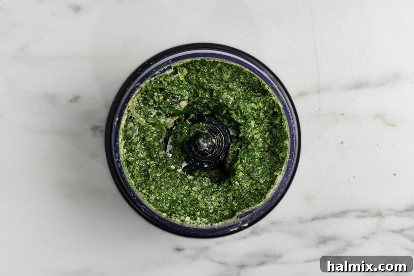 blitzed parmesan and spinach sauce in a food chopper, showing the smooth, vibrant green puree