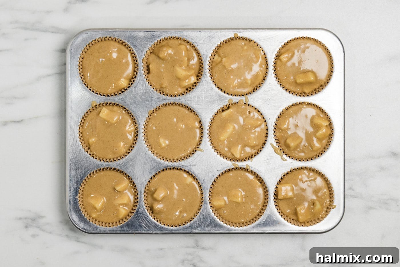 apple muffin batter in a muffin tin