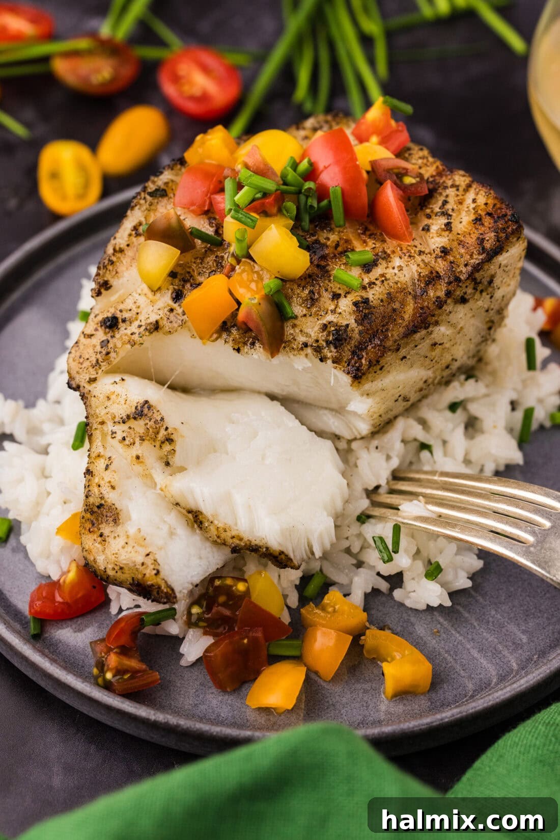 Grilled Chilean Sea Bass broken apart over a bed of rice