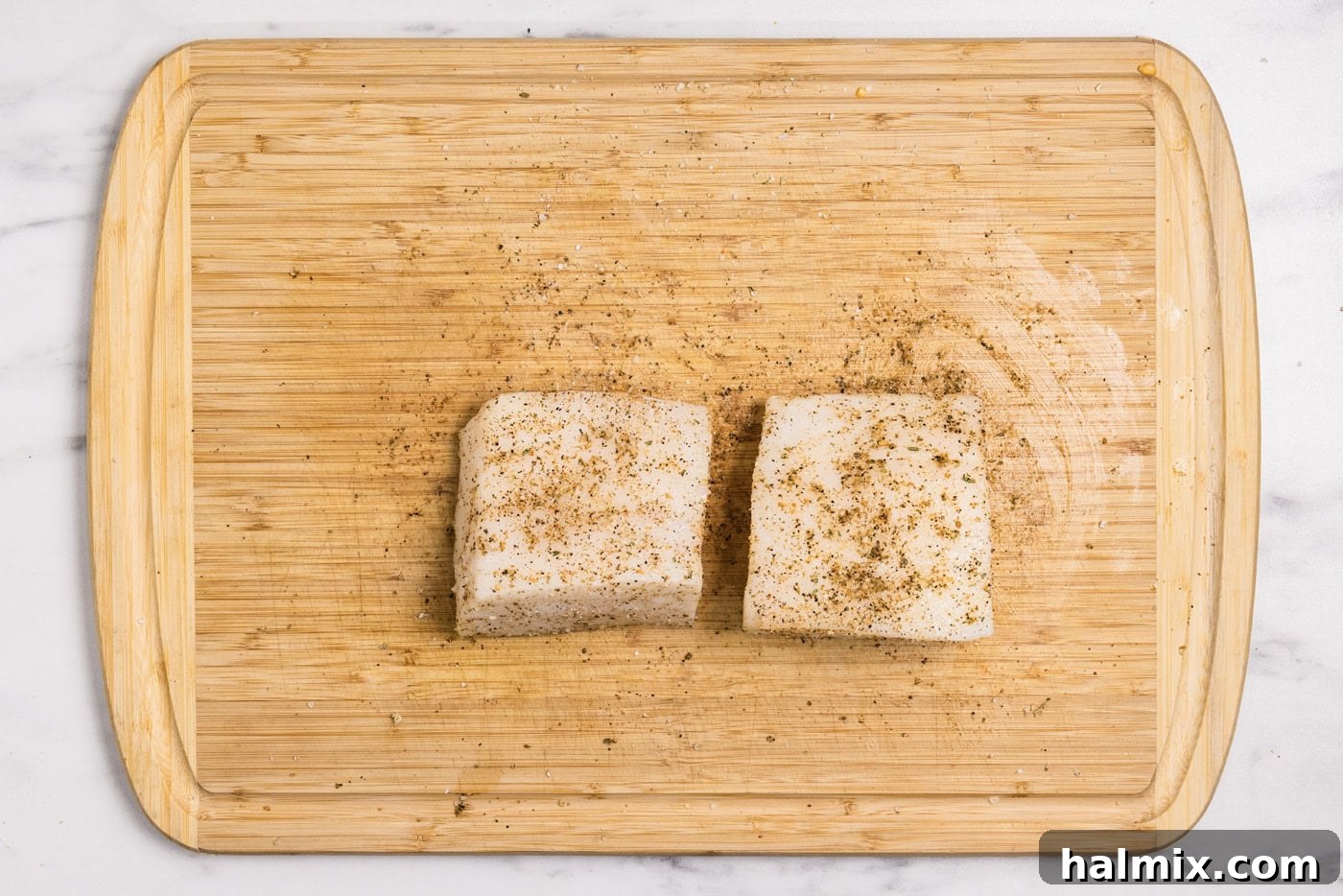 seasoned chilean sea bass filets on a cutting board
