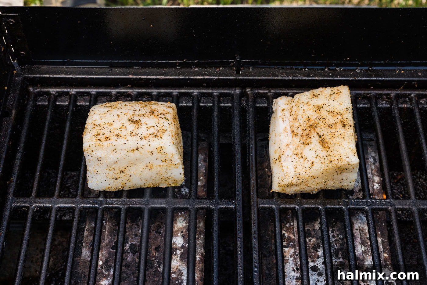 Seasoned chilean sea bass filets on hot grill grates