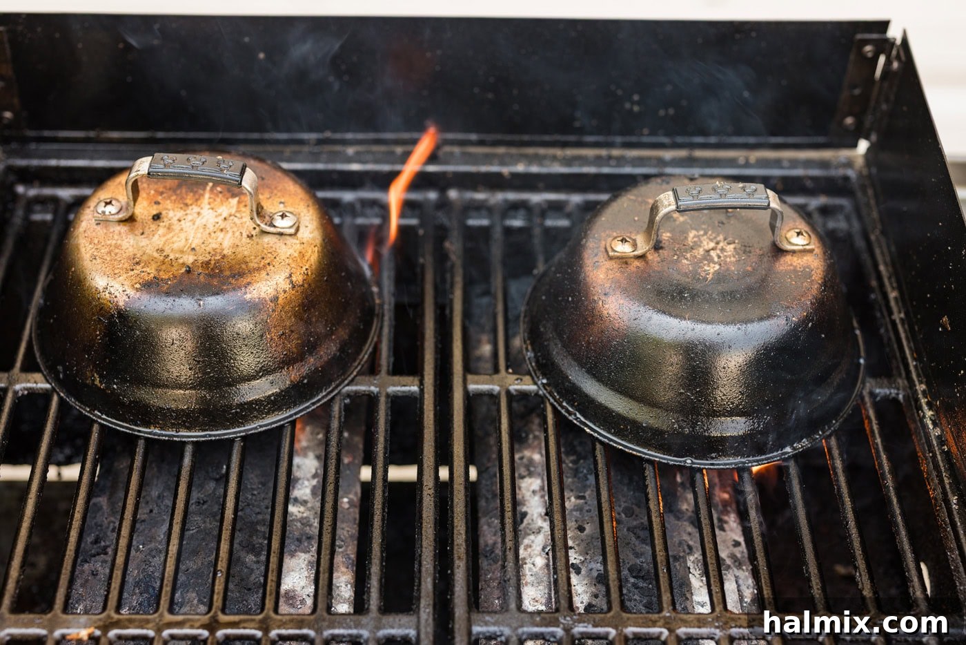 metal basting covers on top of chilean sea bass filets on a hot grill